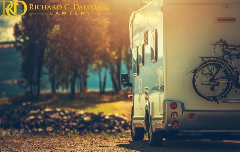 A white camper with bikes on the back in the woods